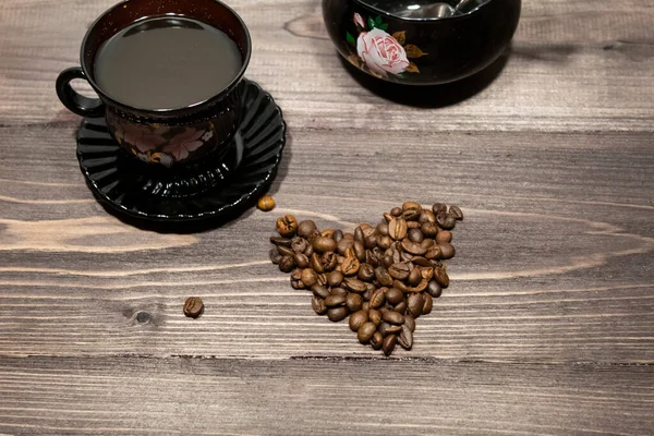 Cup of coffee and coffee beans in the form of a heart.