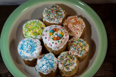 Fırınlanmış Paskalya kekleri, krema ve serpinti ile süslenmiş, bir diş minesi kasesinde durun.. 