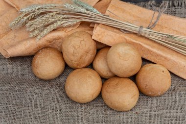 Yukarıdan bak. Çörekler, pide ekmeği ve buğday kulakları jüt kumaşın üzerinde.. 