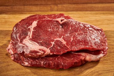 Tahta kesme tahtasındaki çiğ et parçası.