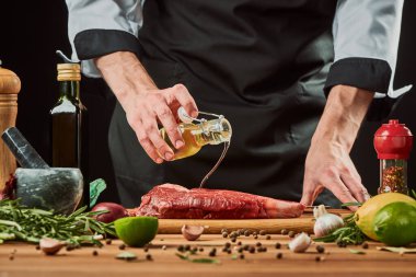 Şef bir parça buluşmaya tohum yağı döküyor.