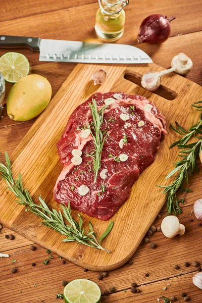 Vue de dessus sur un steak de bœuf cru sur planche à découper en bois — Photo