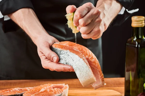 Uomo spremendo calce sulla bistecca di salmone, aggiungendo sapore aspro al pesce — Foto Stock