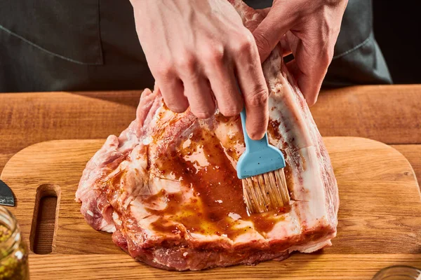 Homem escovando carne crua com escabeche — Fotografia de Stock