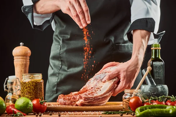 Chef polvilha chili aterrado sobre costelas de carne — Fotografia de Stock