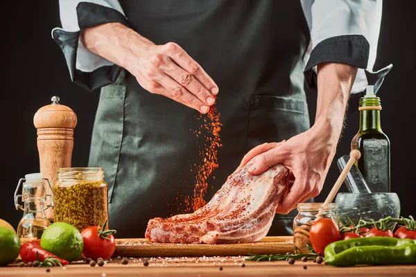 Homem polvilhe uma pitada de pimentão aterrado em costelas de carne — Fotografia de Stock