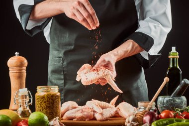 Şef tavuk kanadına kırmızı biber serpti.