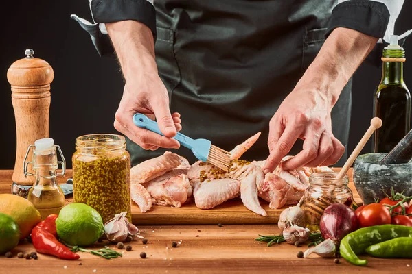 Man borstelend kippenvleugels met Franse mosterd — Stockfoto