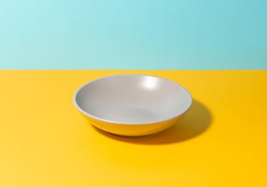 Renkli bir masada gri, derin bir tabak