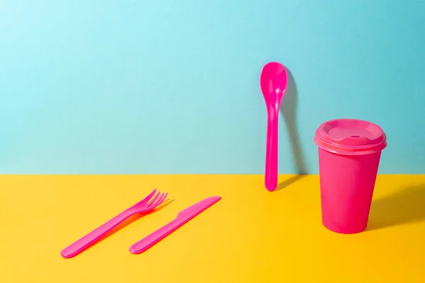 Conjunto de garfo de plástico rosa, faca e colher e xícara de café de papel — Fotografia de Stock
