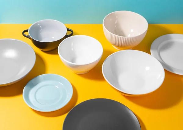노란 배경에 다양 한 접시와 그릇을 놓는 모습 — 스톡 사진