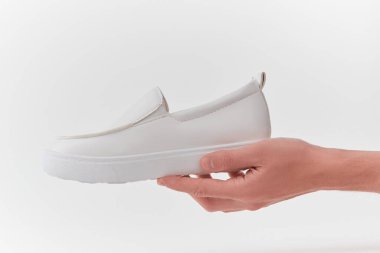 Elinde beyaz deri bir ayakkabı vardı.