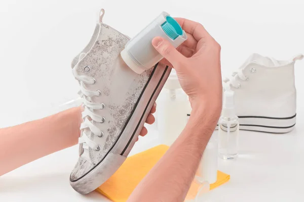 Man removing dirt from a canvas sneaker with a powerful detergent — Stock Photo, Image