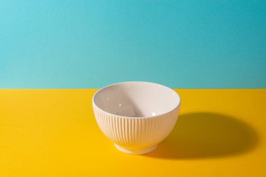 Parlak arkaplanda boş tırtıklı bej kase