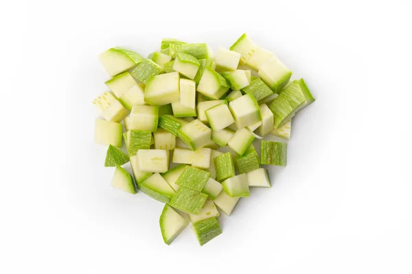 Draufsicht auf einem Haufen gewürfelter grüner Zucchini auf weißem Hintergrund — Stockfoto