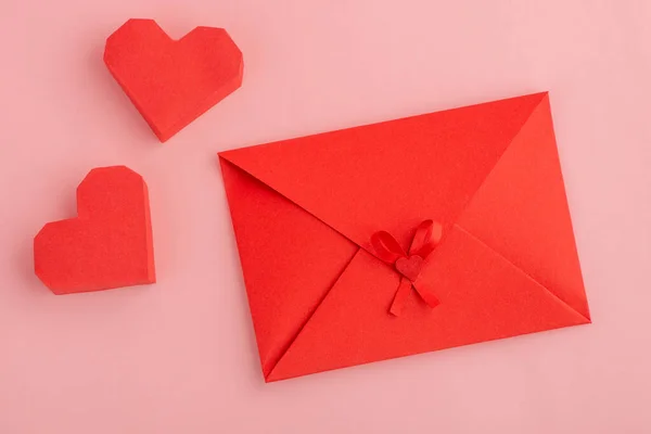 Rode papieren hartjes en enveloppe met liefdesbrief — Stockfoto