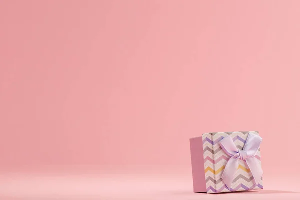 Невелика подарункова коробка на рожевому фоні з простором для копіювання — стокове фото