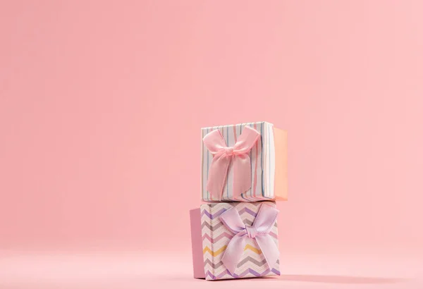 Дві маленькі подарункові коробки на рожевому фоні — стокове фото