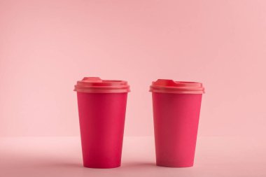 Pembe arka planda iki parlak pembe kahve fincanı.