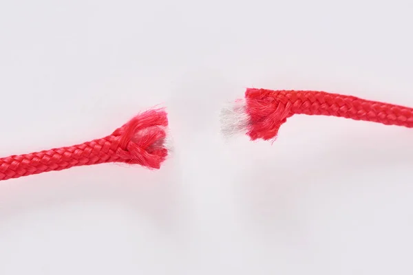 Close-up on broken red paracord on white background — Stock Photo, Image