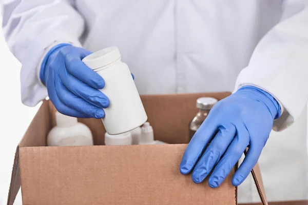 Médico recogiendo medicamentos recetados en una caja de cartón —  Fotos de Stock