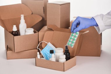Eczacı karton kutularda ilaç ve malzeme topluyor.