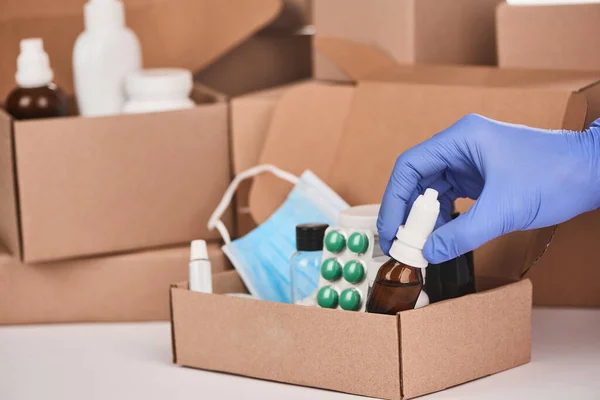 Eczacılar bir şişe burun damlasını ilaçlarla dolu bir kutuya koyuyorlar.