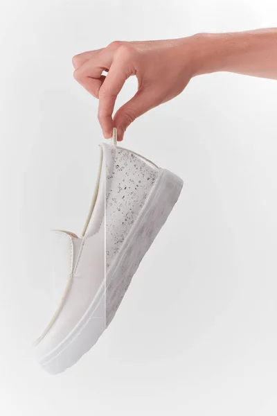 Mână care ține un pantof alb din piele alunecată — Fotografie, imagine de stoc