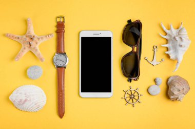 Cep telefonu, güneş gözlüğü ve deniz hatıraları arasında saatler.