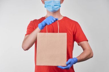 Siparişi teslim eden adam bir kese kağıdına paketlenmiş.