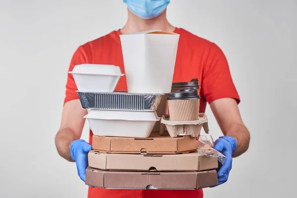 Man holding a big pile of boxes with various food and cups of coffee — Stock Photo, Image