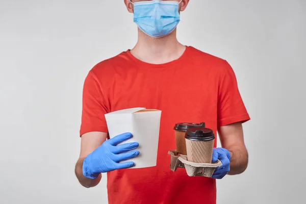 Delivery man holding a box of wok noodles and cups of coffee — Stock Photo, Image