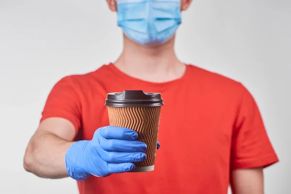 Delivery man giving a paper cup of coffee — Stock Photo, Image
