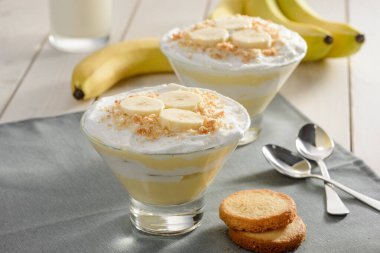 Muzlu kremalı puding ve kurabiye. Ahşap bir masada iki porsiyon servis edilir.