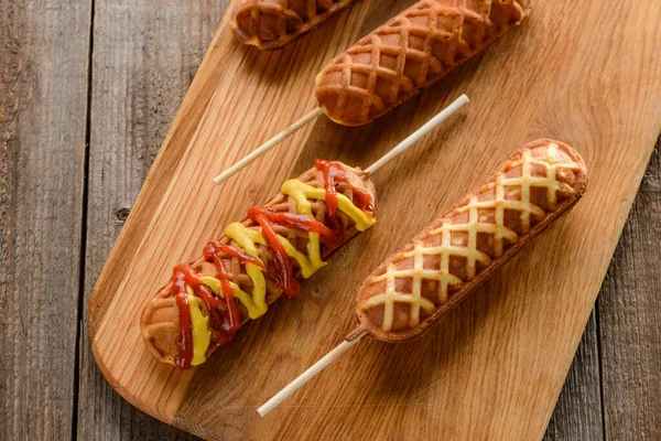 Perros gofres de maíz decorados con zig zags de mostaza y ketchup — Foto de Stock