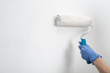 Duvara ikinci bir kat beyaz boya ve silindir sürüyorum.