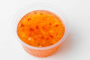 Beyaz arka planda bir fincan tatlı ve ekşi sos.