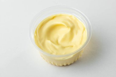 Beyaz arka planda bir fincan peynir sosu.