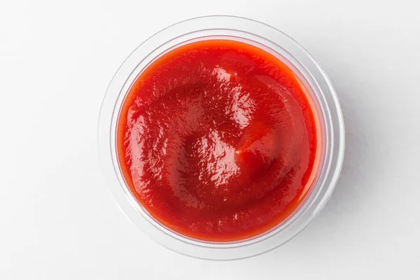 Küçük bir bardak domates sosu, beyaz arka planda üst görünüm. — Stok fotoğraf