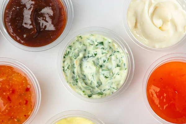 Draufsicht auf verschiedene Saucen in kleinen Tassen auf weißem Hintergrund — Stockfoto