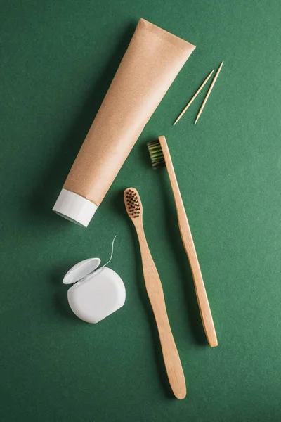Vista superior sobre conjunto de fio dental, pasta de dentes, escovas de dentes de madeira e palitos de dentes — Fotografia de Stock
