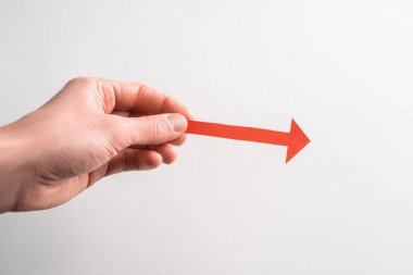 Elinde, sağ tarafı gösteren kırmızı bir ok var.