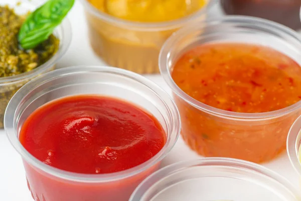 Nahaufnahme auf Tassen mit Tomaten, süßen und sauren Soßen, Senf und Pesto — Stockfoto
