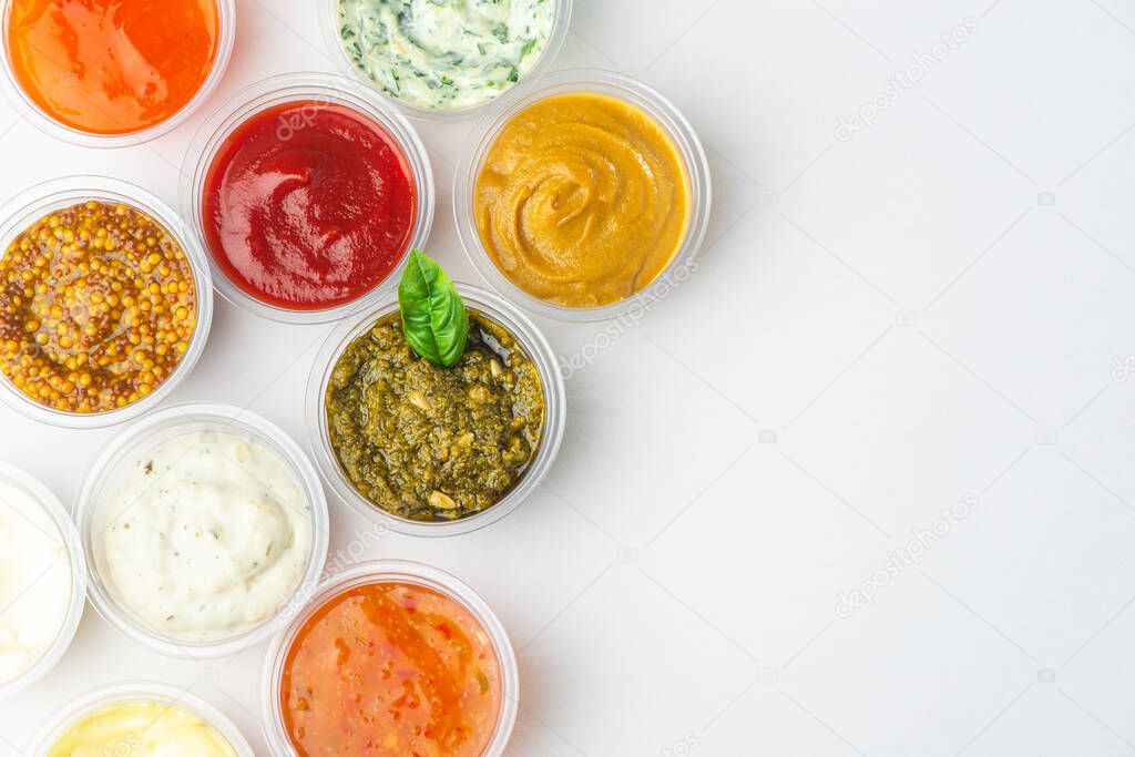 Top view on big assortment of different sauces on white background