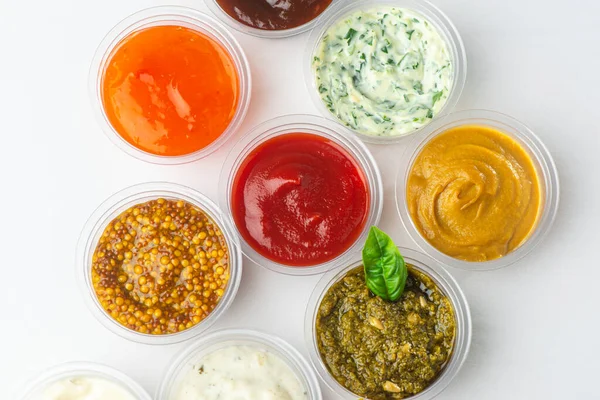 Top view on cups of assorted sauces and condiments on white background — Stock Photo, Image