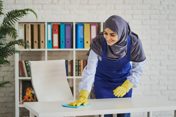 Muszlim nő takarít egy munkahelyet egy irodában — Stock Fotó