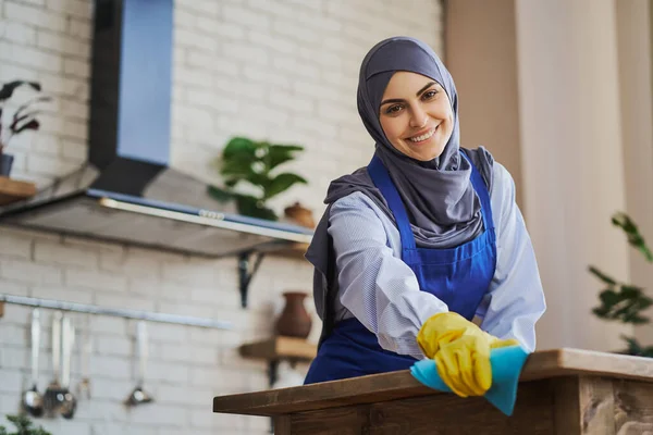 Gyönyörű arab háziasszony takarítja a házát egy ronggyal és kesztyűvel — Stock Fotó