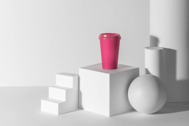 Pembe kahve fincanı, üç boyutlu beyaz kağıt şekiller ve fotokopi alanı.