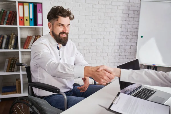Happy man with disability shaking hands with HR