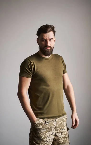 Good-looking military bearded guy on gray background Stock Picture